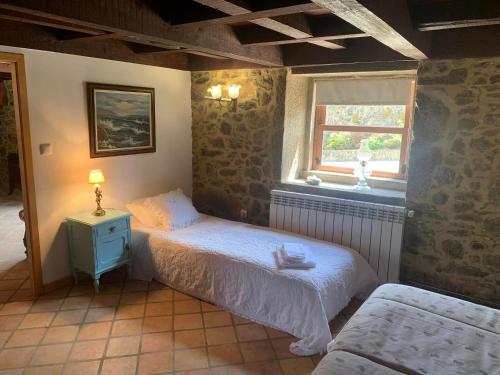 a bedroom with two beds and a window at Vila Margarida in Porreiras