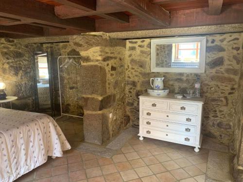 a bedroom with a bed and a dresser and a window at Vila Margarida in Porreiras