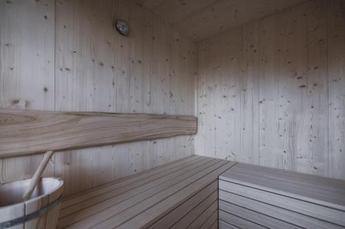 a sauna with wooden walls and a clock on the wall at Kessler's Mountain Lodge in Natz-Schabs
