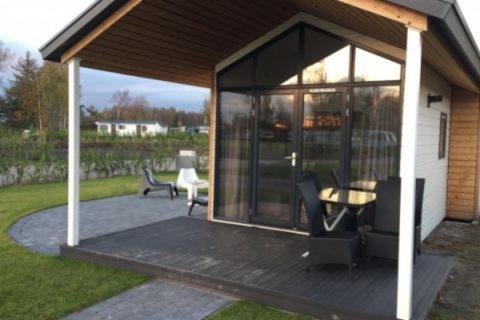 a screened in porch with a table and chairs at Amici Camping Urlaub am Effelder Waldsee in Wassenberg