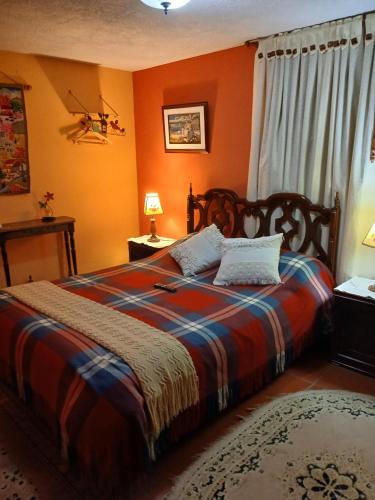 a bedroom with a bed with an orange wall at Pedregal Sopó in Sopo
