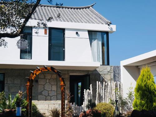 una casa con un arco davanti di Leisure Courtyard Seascape Designer Hotel a Dali