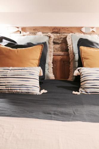 - un lit avec plusieurs oreillers dans l'établissement Duplex accès jacuzzi illimité Z, à Villedieu-les-Poêles