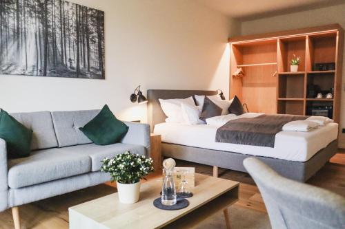 a living room with a bed and a couch at Das Parkhotel in Bad Wörishofen