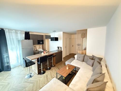 un salon avec un canapé et une cuisine dans l'établissement Appartement cosy à 10 minutes champs Élysée, Trocadéro, à Rueil-Malmaison