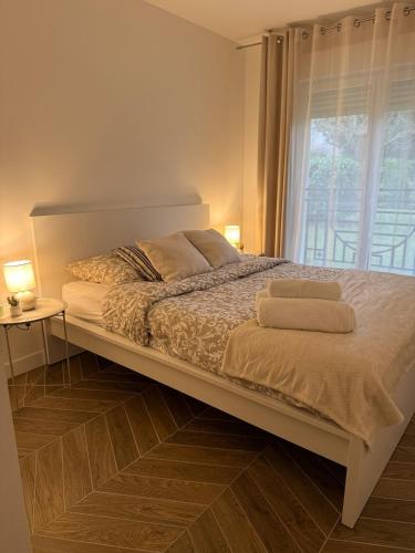 une chambre avec un lit avec deux serviettes dessus dans l'établissement Appartement cosy à 10 minutes champs Élysée, Trocadéro, à Rueil-Malmaison