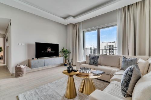 a living room with a couch and a tv at Yas Escape -2BR by SLV in Abu Dhabi