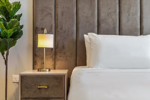 a bedroom with a bed and a lamp on a night stand at Yas Escape -2BR by SLV in Abu Dhabi