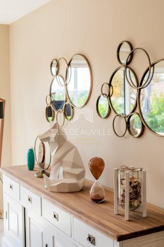 une table avec trois miroirs sur un mur dans l'établissement Villa Saint Martin - 23 couchages, à Saint-Martin-aux-Chartrains