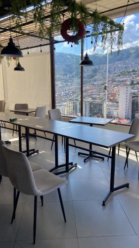 a table and chairs in a room with a view at Hostal La Terraza - Roof Terrace Overlooking The North and Historic Centre in Quito