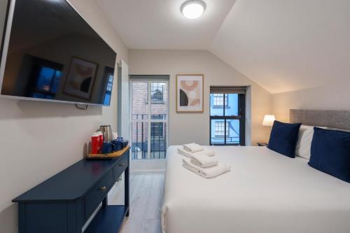 una camera da letto con un grande letto bianco e un comò nero di The Temple Bar Lane a Dublino