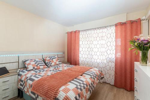 una camera da letto con un letto e un vaso di fiori di Golden Sunset a Benalmádena