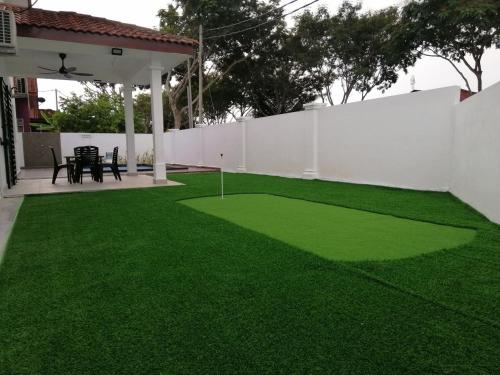 a yard with green grass and a white fence at casa610 HOMESTAY PD in Port Dickson