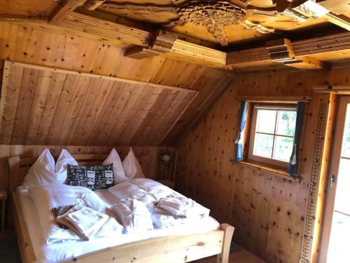 a bedroom with a bed in a wooden room at Penzhütte in Bad Sankt Leonhard im Lavanttal
