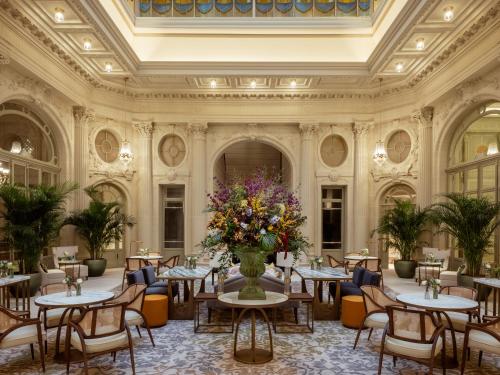 a restaurant with tables and chairs and flowers in a room at Corinthia Grand Hotel Astoria Brussels in Brussels