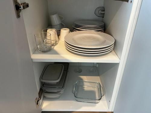 a cupboard with plates and dishes on a shelf at RN Studios Premium Apt 805 - Mandi Hospitalidade in Maceió