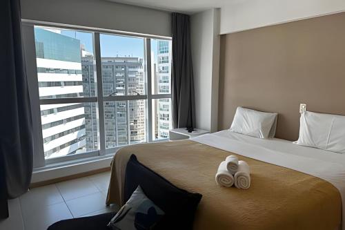 a hotel room with a bed with two towels on it at Saint Moritz, centro de Brasilia in Brasilia
