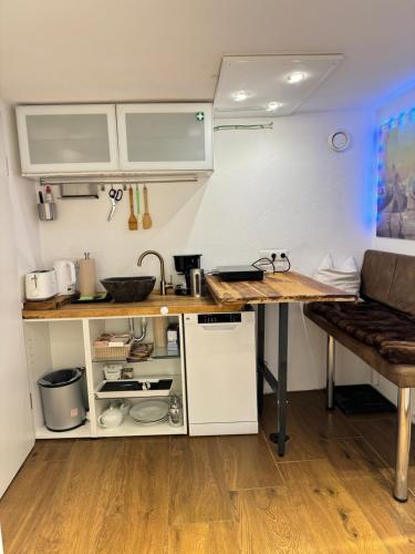 a small kitchen with a counter and a table at Schöne Souterrain Wohnung in Herzogenrath mit Sauna! in Herzogenrath