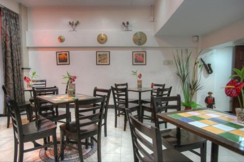 a dining room with tables and chairs and plants at Fersal Hotel - Manila in Manila