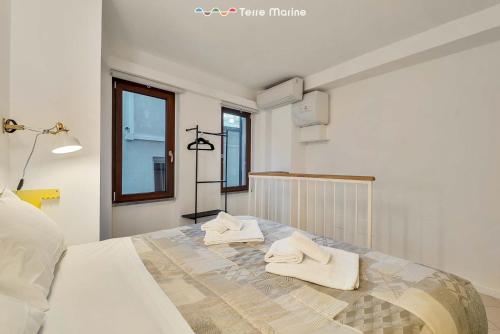 a bedroom with a bed with towels on it at Yellow Submarine, Terre Marine in Manarola