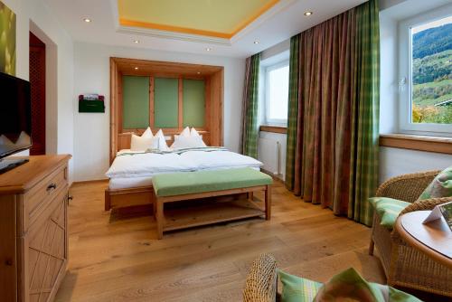 a hotel room with a bed and a television at Wanderhotel Kirchner in Bramberg am Wildkogel