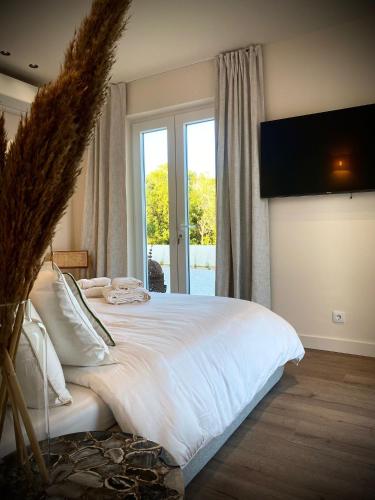a bedroom with a large white bed with a large window at So Magoito in Sintra
