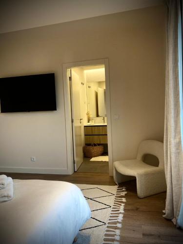 a bedroom with a bed and a bathroom with a mirror at So Magoito in Sintra