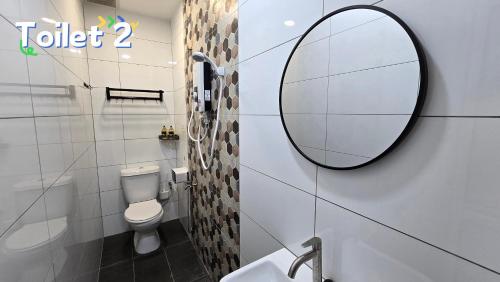a bathroom with a toilet and a mirror on the wall at Skudai - The 9 Homestay at Tmn Teratai - 2min UTM in Skudai