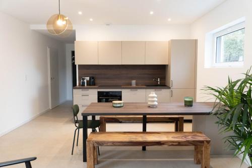 une cuisine avec une table en bois et une salle à manger dans l'établissement La Villa Les Berges de l 'Ill, à Mulhouse