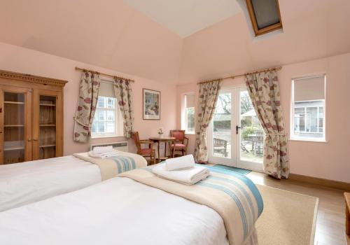 - 2 lits dans une chambre avec fenêtres dans l'établissement Luffness Castle Cottage, à Aberlady