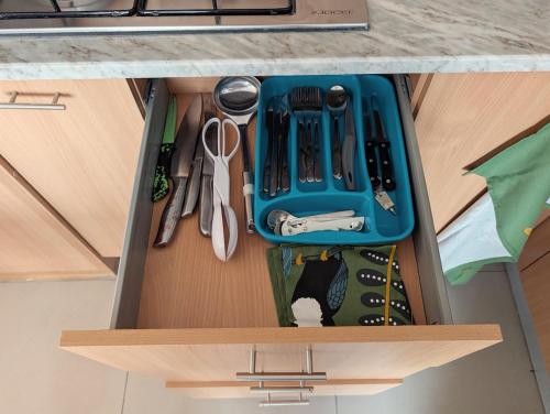 a drawer with a blue container and tools in it at SeafrontView - Cozy T1 Apartment 2 in Praia
