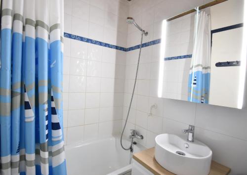 une salle de bain avec un lavabo, une baignoire et une douche dans l'établissement Chalosse - Seignosse - Agréable appartement tout proche de l'océan, à Seignosse