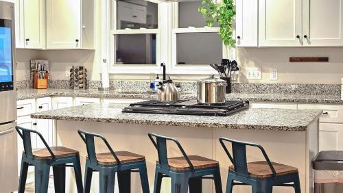 a kitchen with a counter with four chairs around it at 4 BR - King beds - perfect for HPU, Furniture Market, Greensboro, Winston in High Point