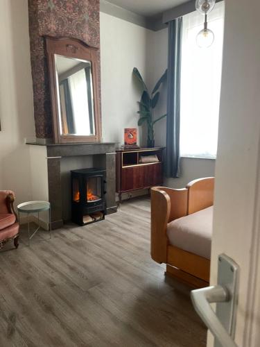 a bedroom with a fireplace and a couch and a mirror at The Art Deco Room in Antwerp
