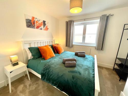 a bedroom with a bed with orange and green at New Modern 2 Bed with parking in BISHOPS STORTFORD, close to Stansted Airport! in Bishops Stortford