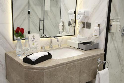 a bathroom with a sink and a mirror at MADEN Al Rawda مادن الروضة in Al Madinah