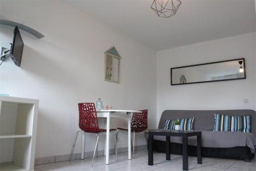 un salon avec un canapé, une table et des chaises dans l'établissement Appt Studio LA ROCHELLE - LR100-330, à La Rochelle
