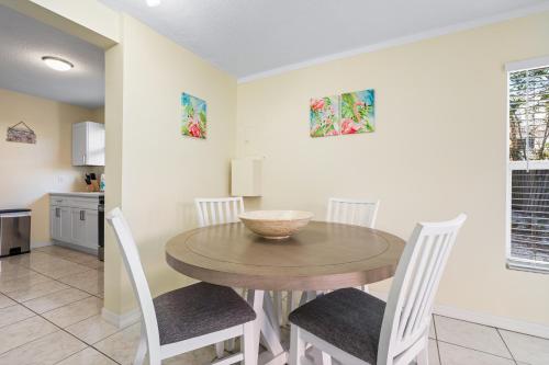 a kitchen and dining room with a wooden table and chairs at Living the Dream By Beachside Management in Siesta Key