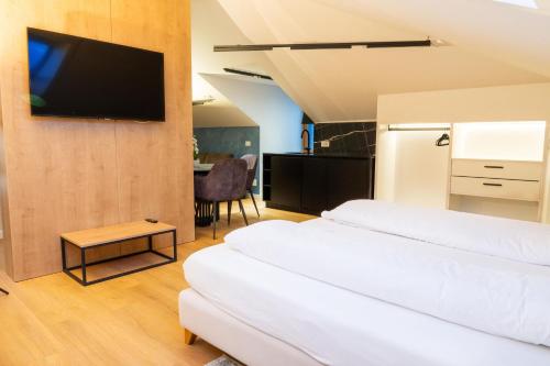 two beds in a room with a tv on a wall at Boutique Hotel OchSen Self-Check-In in Bad Ragaz