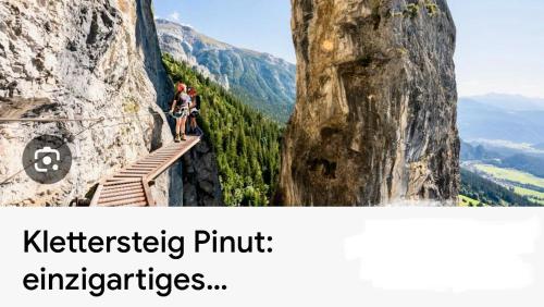 two people are standing on a ledge on a mountain at Casa Ladina 2 in Falera