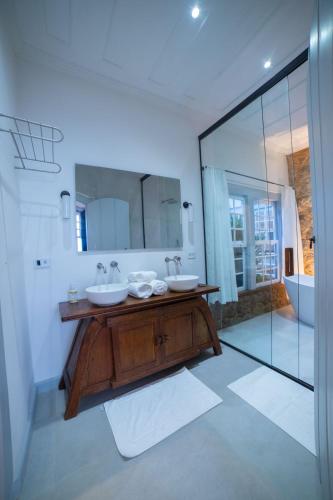 a bathroom with two sinks and a large mirror at Casa Odara Paraty in Paraty
