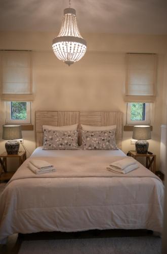 a bedroom with a large bed with a chandelier at Κόρυς in Karpenision