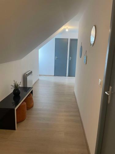Cette chambre vide dispose d'un couloir avec une table et un miroir. dans l'établissement Charmante maison familiale au Pouliguen, au Pouliguen