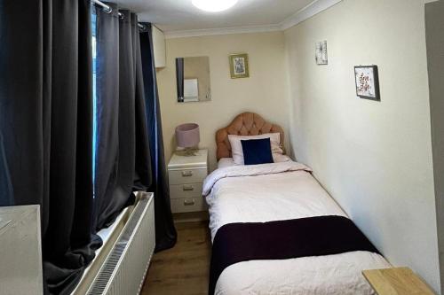 a small bedroom with two beds and a tv at 3 Bed Cottage Retreat - Private Garden & Parking in Orpington