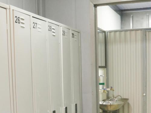 a row of white lockers in a bathroom at Pupa House - Capsule Hotel - Adults Only in Tamarindo