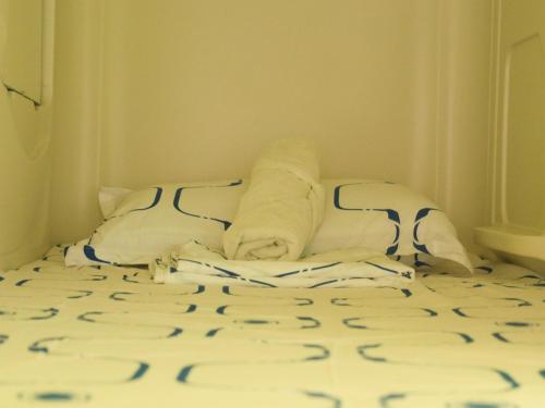 a bed with towels and pillows on it at Pupa House - Capsule Hotel - Adults Only in Tamarindo