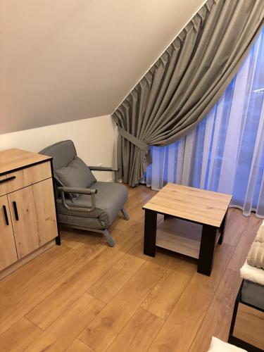 a living room with a chair and a table at Catalpa Camp Ośrodek Rekreacyjno-Wypoczynkowy nad jeziorem Gopło in Piotrków Kujawski