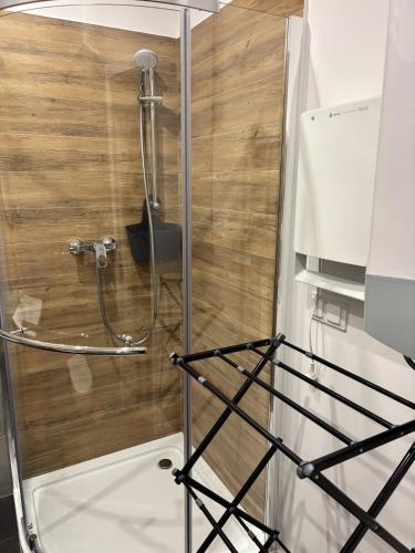 a shower in a bathroom with a wooden wall at Catalpa Camp Ośrodek Rekreacyjno-Wypoczynkowy nad jeziorem Gopło in Piotrków Kujawski
