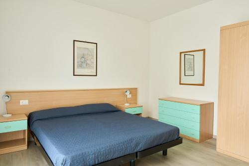 a bedroom with a blue bed and two night stands at Appartamenti in Residence Portosole e Residence Tamerici con piscina-Cavallino Treporti in Cavallino-Treporti
