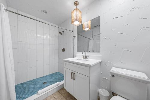 a white bathroom with a sink and a toilet and a tub at Crescent Beach Villas By Beachside Management in Siesta Key